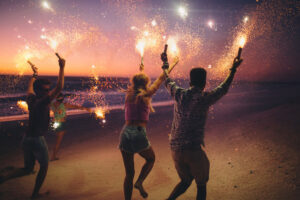 people w sparklers on beach